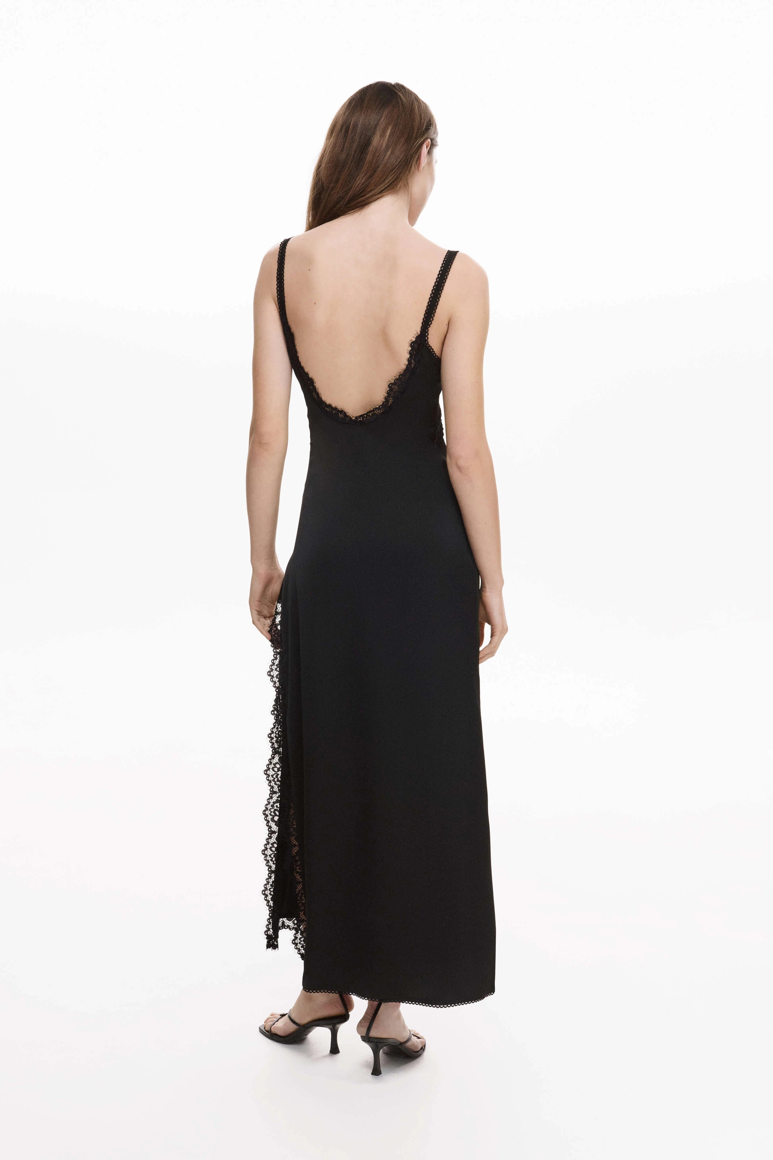 Back view of black lace maxi dress with open back and fitted silhouette
